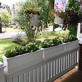 white flower boxes sit on top of porch railings | Deck railing .