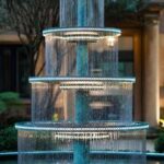 A large outdoor fountain made from bronze and lit with LED .