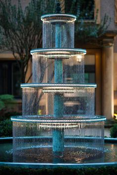 A large outdoor fountain made from bronze and lit with LED .