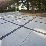 dress up the gaps in the concrete paving slabs with mosaic tiles .